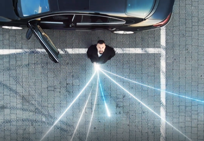 Man stood next to a car with data connections shooting from his phone.